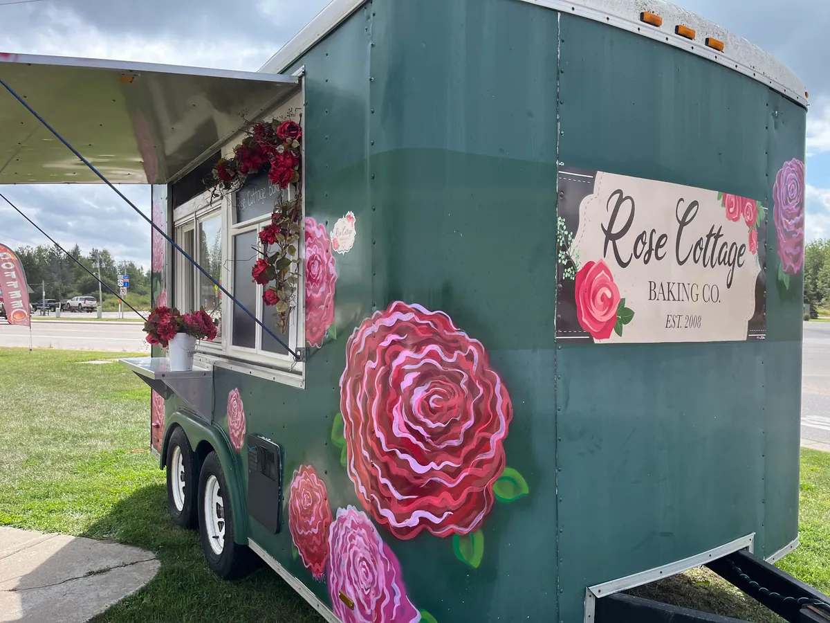 Rose Cottage Baking Co. rose-painted food truck with its hand-lettered sign